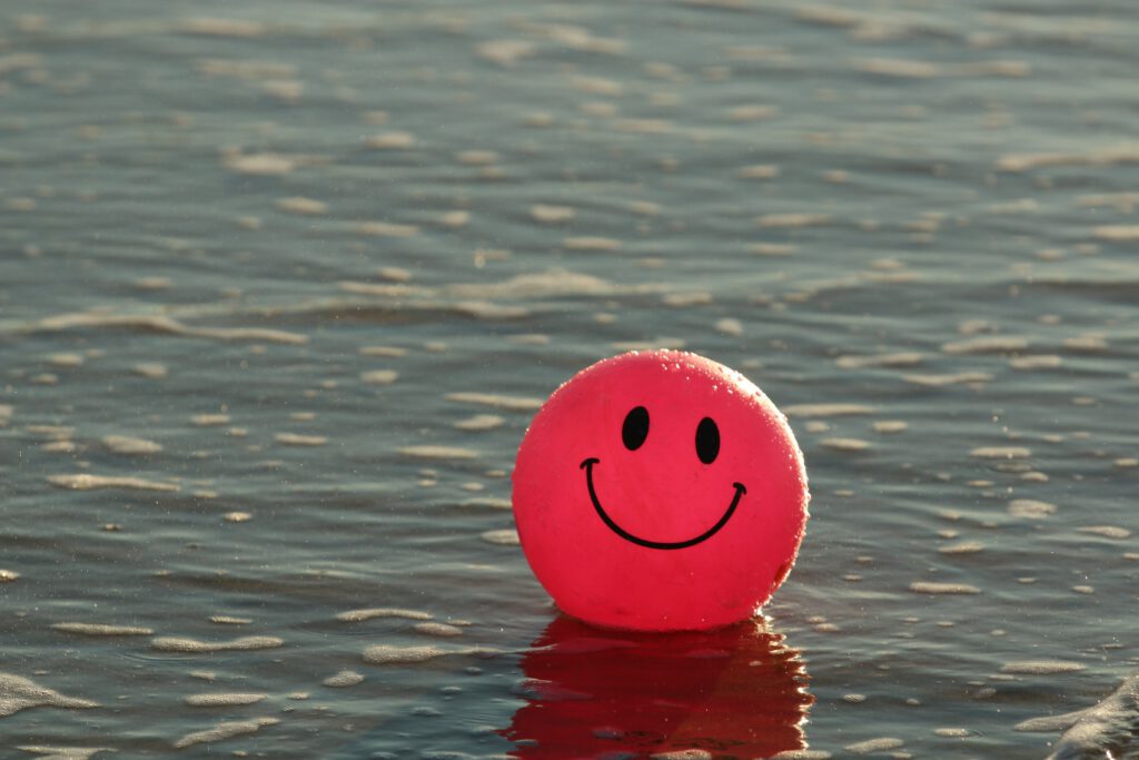 Wasserball mit einem Lächeln gezeichnet schwimmt im Meer