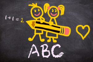 Tafel mit einer einfach 1+1 Rechnung einem ABC und Strichmännchen Kinder mit einem riesigen Bleistift und einem Herz